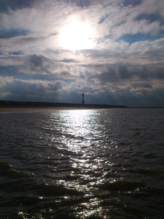 Strand und Neuer Leuchtturm im Gegenlicht