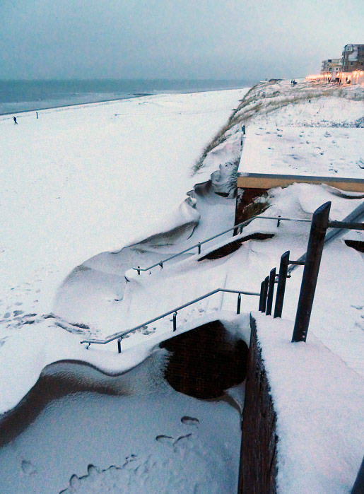 Blick von der Uhrtreppe zum verschneiten Strand