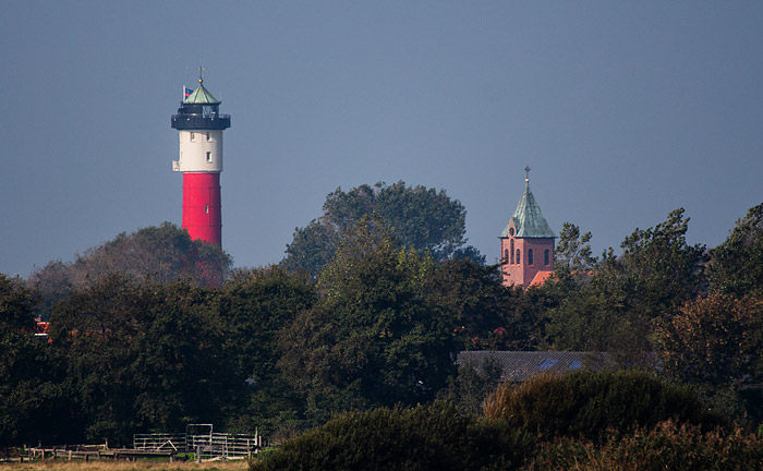 Leuchtturm und Kirche durch Teleobjektiv gesehen