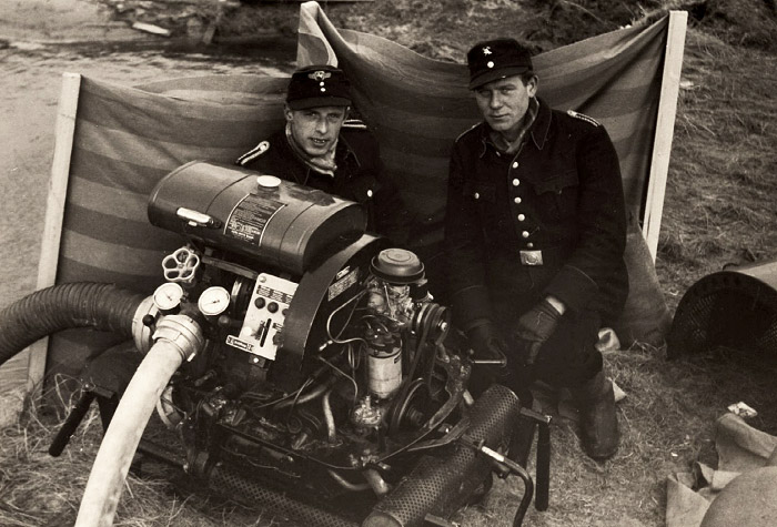 Mitglieder der Freiwilligen Feuerwehr mit Pumpe